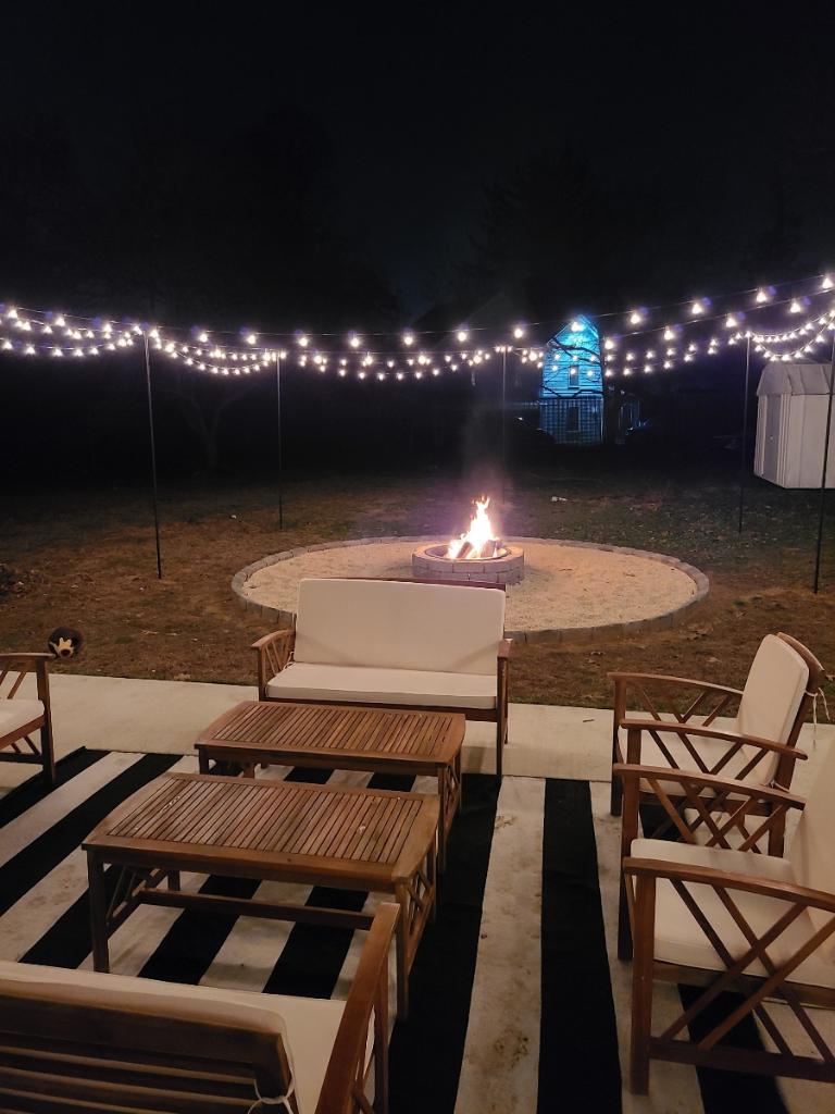 Finished custom fire pit at night with string lights
